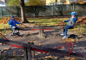 Chłopcy na bujaku w jesiennym ogrodzie przedszkolnym