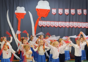 Dzieci podczas tańca z białymi i czerwonymi chustami szyfonowymi