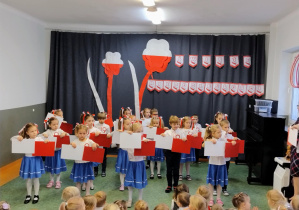 Dzieci podczas tańca z białymi i czerwonymi kartkami