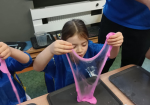 Dziewczynka tworzy rozciągliwe lusterko z własnoręcznie uformowanej masy sensorycznej