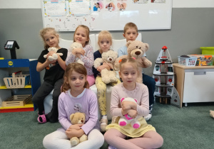 Dzieci pozują do zdjęcia ze swoimi pluszowymi misiami