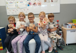 Dzieci pozują do zdjęcia ze swoimi pluszowymi misiami