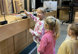 Dziewczynka uderza młotkiem sędziowskim