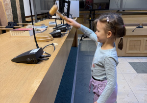 Dziewczynka uderza młotkiem sędziowskim