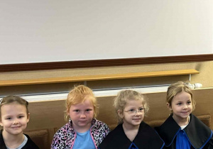 Dziewczynki siedzą w ławie sądowej