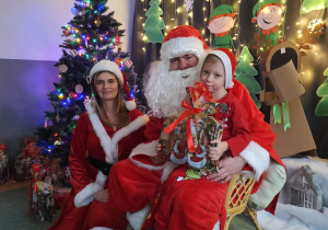 Zdjęcie chłopca pozowane z Mikołajem w świątecznej aranżacji