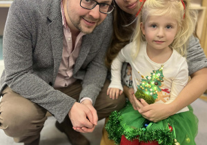 Zdjęcie dziewczynki z rodzicami na warsztatach świątecznych