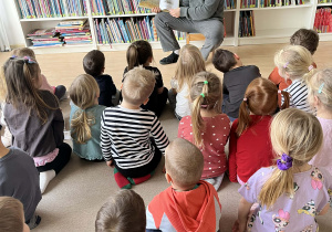 Dzieci w bibliotece miejskiej podczas słuchania czytanej bajki