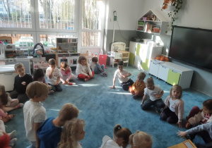 "Głośne Czytanie" - dzieci słuchają książki czytanej przez jednego z rodziców