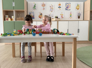 dziewczynki układają klocki przy stoliku podczas sesji zdjęciowej