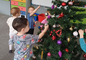 Dzieci ubierają choinkę