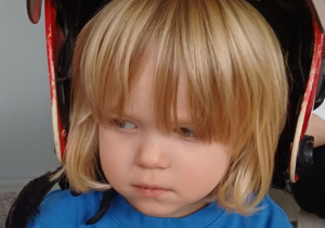 chłopiec pozuje w kasku strażaka