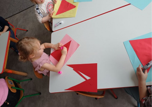 dzieci wykonują pracę plastyczną "Mikołaj"