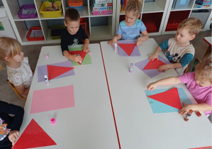 dzieci wykonują pracę plastyczną "Mikołaj"