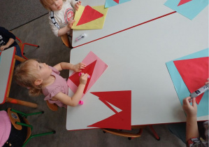 dzieci wykonują pracę plastyczną "Mikołaj"