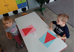 dzieci wykonują pracę plastyczną "Mikołaj"