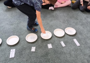 Chłopiec odkłada literę na przypisany jej talerzyk