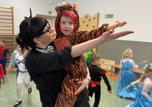nauczycielka tańcząca z dzieckiem w stroju karnawałowym