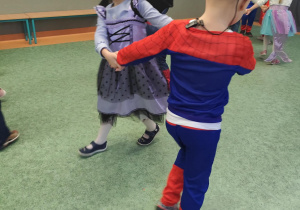 Dzieci tańczące na sali gimnastycznej podczas balu karnawałowego