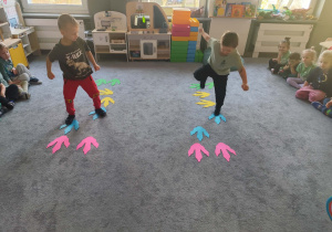 Dzieci podczas zabaw na dywanie związanych z Dniem Dinozaura