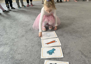 Dziewczynka układająca plansze związane z pierwszą pomocą