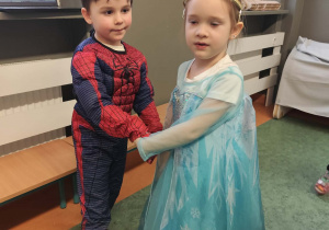 Taniec dziewczynki i chłopca na sali gimnastycznej podczas balu karnawałowego