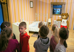 Dzieci stoją w pomieszczeniu wzorowanym na pokój Misia Uszatka