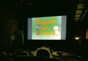 Dzieci siedzą w kinie i oglądają bajkę