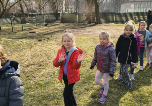 Dzieci podczas spaceru w korowodzie po ogrodzie przedszkolnym
