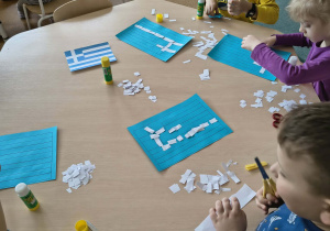 Dzieci podczas wykonywania pracy plastycznej przedstawiającej flagę Grecji