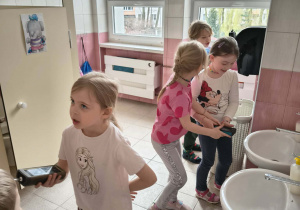 Dzieci, z wykorzystaniem mierników, sprawdzają poziom wilgoci w łazience