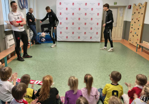 Dzieci obserwują pokaz trików z piłką nożną