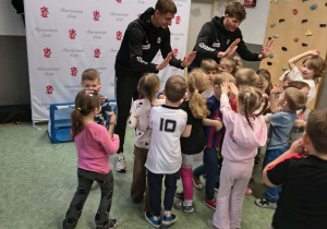 Dzieci przybijają piątki z piłkarzami