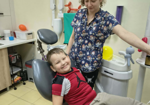 Chłopiec siedzi na fotelu stomatologicznym