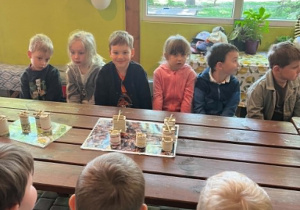 Dzieci podczas wykonywania świeczek z wosku siedzące przy stołach