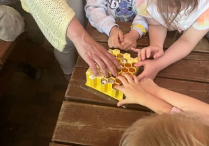 Dzieci obserwujące imitację plastra miodu
