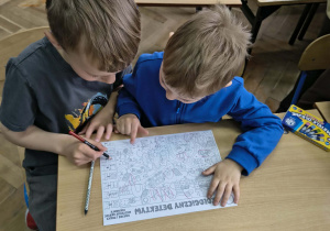 Chłopcy rozwiązują kartę pracy