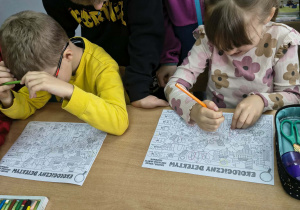 Dzieci rozwiązują karty pracy