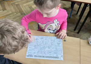 Dziewczynka rozwiązuje kartę pracy