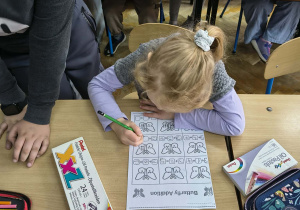 Dziewczynka rozwiązuje kartę pracy