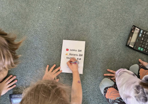 Dziewczynka podpisuje prawidłowo wystawioną fakturę za zakup owoców