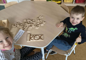 Dzieci prezentują ułożony z klocków wyraz "koc"