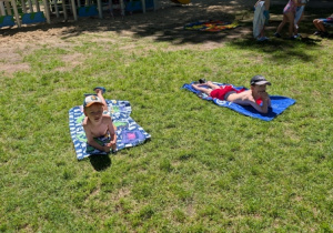 Dzieci odpoczywające w ogrodzie z okazji Dnia Plażowicza - zakończenie roku przedszkolnego