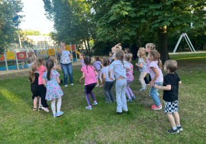 Dzieci tańczą w ogrodzie przedszkolnym