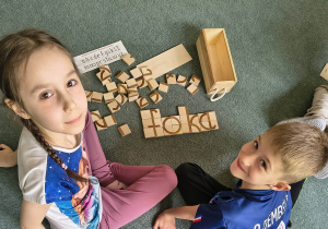 Dzieci prezentują ułożony z klocków wyraz "foka"