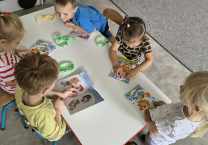 Dzieci oglądają upominki otrzymane od solenizantki
