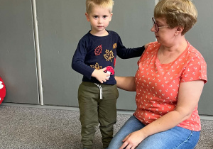 Chłopiec prezentuje nauczycielce muchomora na swojej bluzce