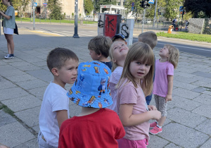 Dzieci ustawione w parach na chodniku przed przejściem dla pieszych