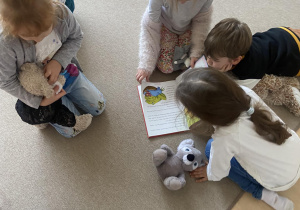 Dzieci w bibliotece kolorują na dywanie