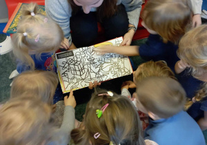 Dzieci wskazują zauważone przedmioty na ilustracji w książce